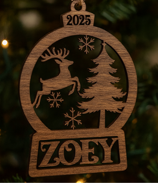 Wooden ornament with reindeer, tree, and snowflakes design, featuring the year 2025 and name 'Zoey', hanging on a Christmas tree.